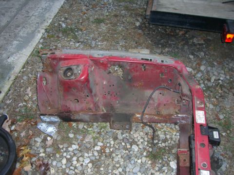 1988 Ford Bronco - This red vehicle firewall part shows significant rust and damage, indicating it is a used component.