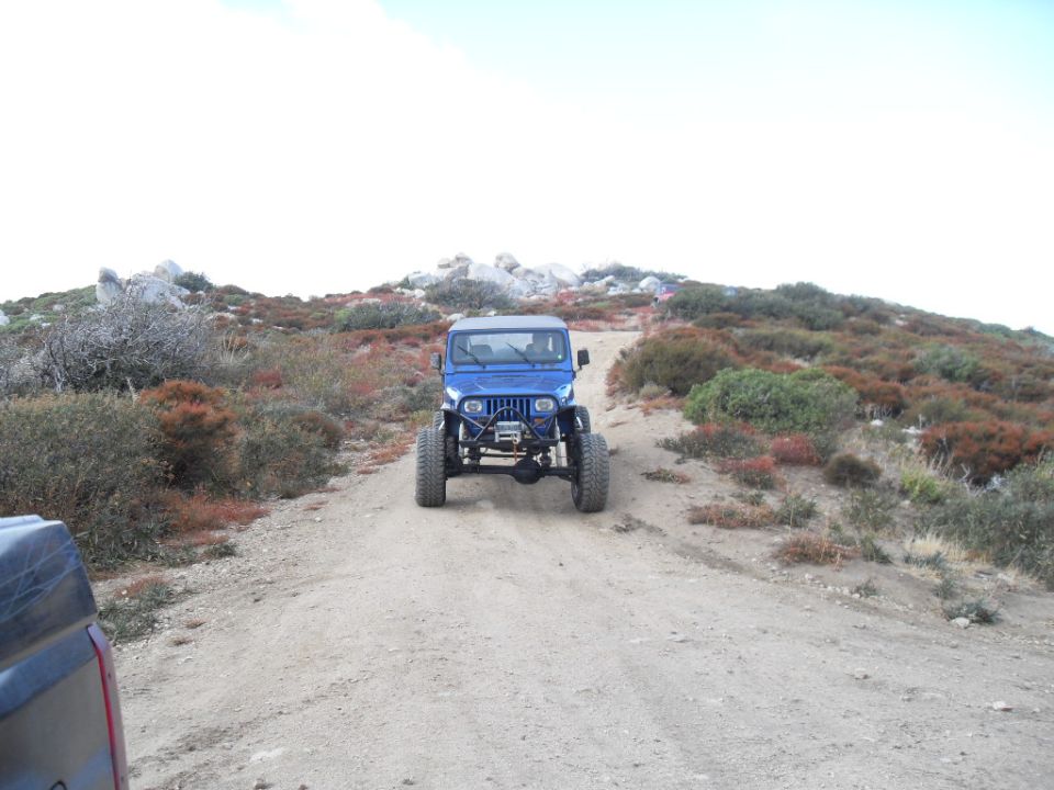 Blue Jeep Wrangler with winch on dirt road