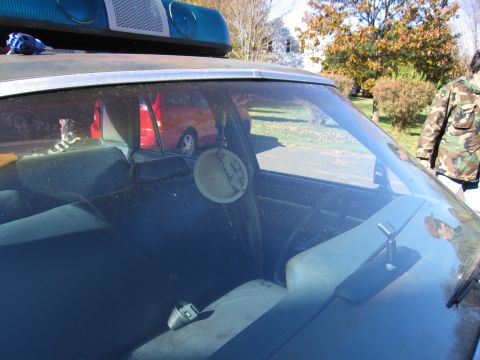 2001 Ford Crown Victoria - Interior of a police car, with a red vehicle reflected in the windshield.