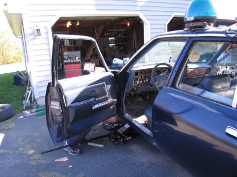 2001 Ford Crown Victoria - The interior of a dark blue vehicle is visible with both front doors open, revealing the dashboard and seating area.