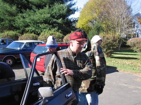 2001 Ford Crown Victoria - People gather near vehicles on a sunny day with fall foliage.