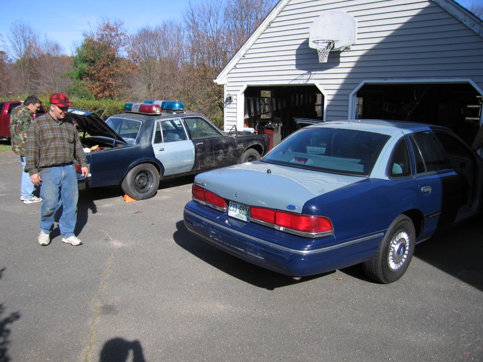 Two-tone blue and gray 2001 Ford Crown Victoria police car, rear view, license plate 233-693