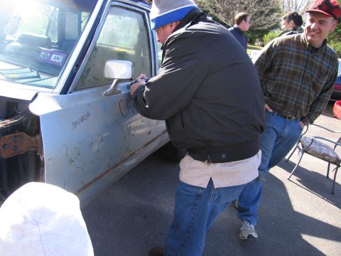 2001 Ford Crown Victoria - A light blue car door is visible with 'CAR' scrawled on it and a 2003 license plate in the window.