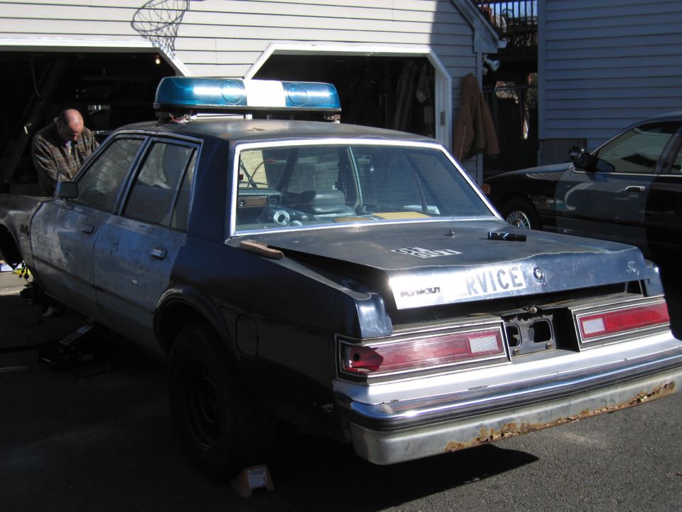 Rear view of a police car with a light bar and "KVICE" text on the trunk