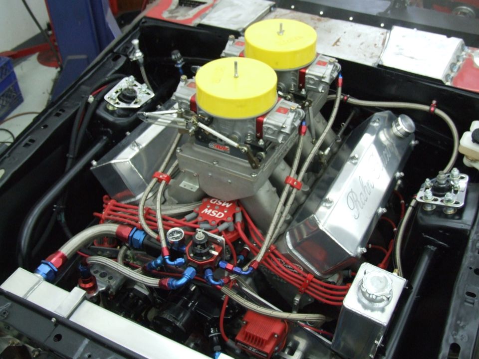 Custom V8 engine with dual carbs, yellow caps, red MSD distributor, braided lines
