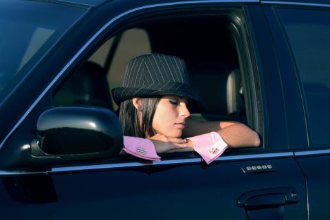 2003 Mercury Marauder - A woman in a fedora and pink cuffs rests her arms on the window frame of a 2003 Mercury Marauder.