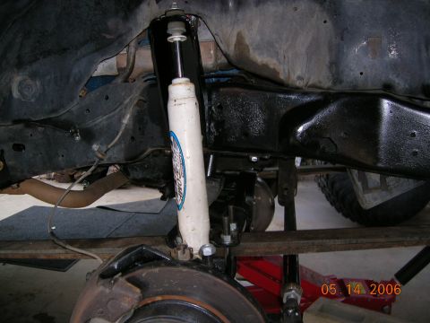 1985 Ford Bronco - Close-up view of a vehicle's suspension system, showing the shock absorber and brake components.