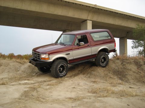 1996 Ford Bronco - 1996 Ford Bronco navigates a dirt incline under a concrete overpass.