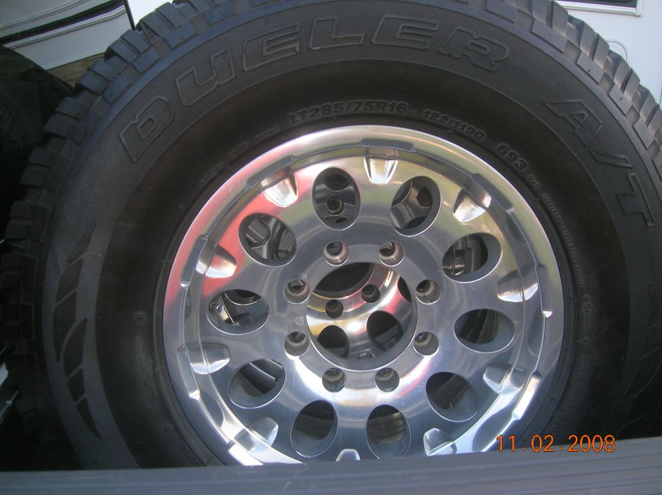 Tire with 'DUELER A/T' text and a chrome multi-spoke wheel