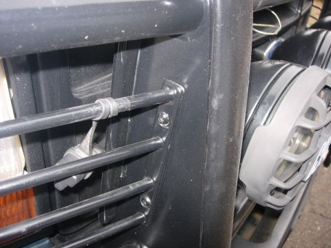 1993 Ford Bronco - Close-up view of a vehicle's grille and speaker assembly, with a wrench attached to the grille bars.