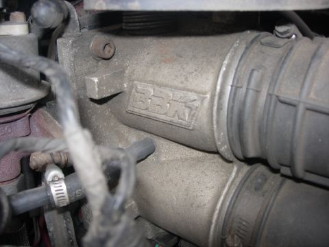 1993 Ford Bronco - A close-up view of an engine part with embossed text and connected hoses.