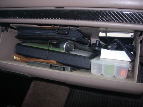 1993 Ford Bronco - The contents of a vehicle's glove compartment are visible, including various bags and a container of fuses.