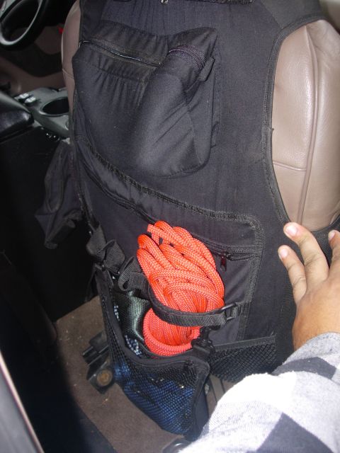 1993 Ford Bronco - A black seat organizer with red rope is attached to the interior of a vehicle.