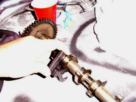 2007 Ford Mustang - A camshaft and timing gear are being held and examined.