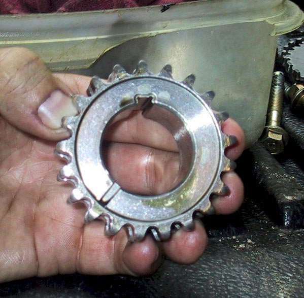 Hand holding a metal toothed pulley with a keyway slot