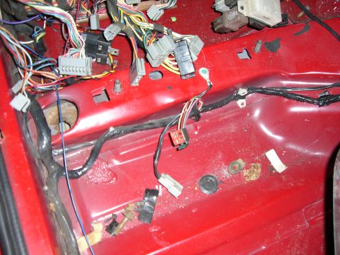 1988 Ford Bronco - A complex vehicle wiring harness is visible on red interior panels.