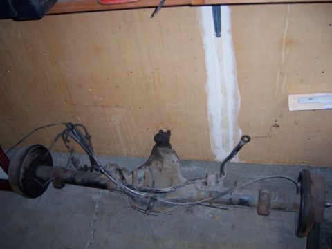 1991 Ford Bronco - Rear axle assembly with drum brakes and brake lines, likely for an older truck or SUV.