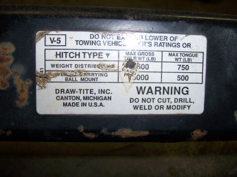1991 Ford Bronco - Label on a trailer hitch shows weight capacities and a warning not to modify the part.
