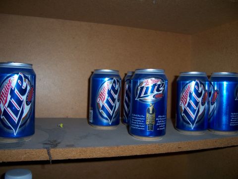 1991 Ford Bronco - A collection of Miller Lite beer cans are stored on a shelf.
