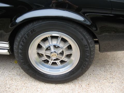 1968 Shelby GT500 - Close-up of a black car's wheel, showing a distinctive silver rim and tire details.