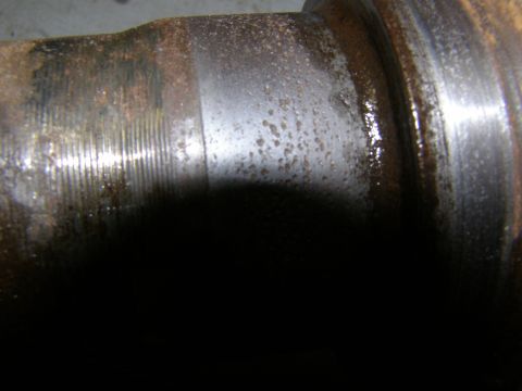 1993 Ford Bronco - This is a close-up view of a heavily rusted and worn metal axle component.