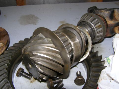 1993 Ford Bronco - Close-up of a damaged differential gear set, including bearings and fasteners, on a workbench.