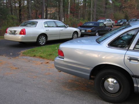 1991 Ford LTD Crown Victoria - A silver sedan is parked in a driveway with other vehicles visible in the background.