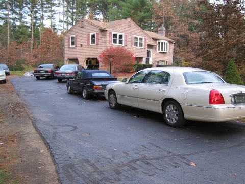 1991 Ford LTD Crown Victoria - Several cars are parked on a driveway in front of a house.