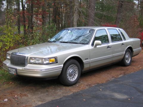 1991 Ford LTD Crown Victoria - A silver Lincoln Town Car from the 1990s is seen from the front quarter angle on a paved surface.