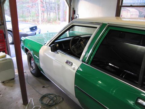 1991 Ford LTD Crown Victoria - A two-tone Ford Crown Victoria, green and white, sits in a garage with another similar vehicle behind it.