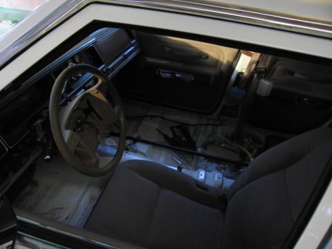 1991 Ford LTD Crown Victoria - Interior view of a car with seats and dashboard visible, floor stripped to reveal metal.