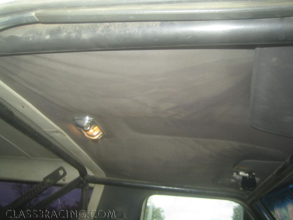 Interior headliner and roll cage of a vehicle with a small dome light illuminated