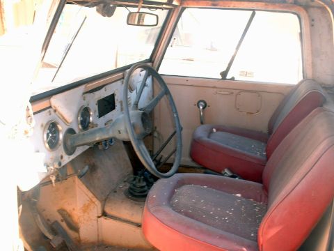 1961 International Scout 800 - The interior of a 1961 International Scout 800 shows its age with dusty red seats and a utilitarian dashboard.
