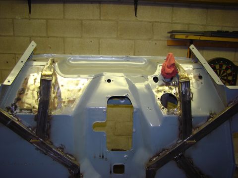 1948 Jeep Wrangler - Firewall of a vehicle being worked on, showing metal repairs and primer application.
