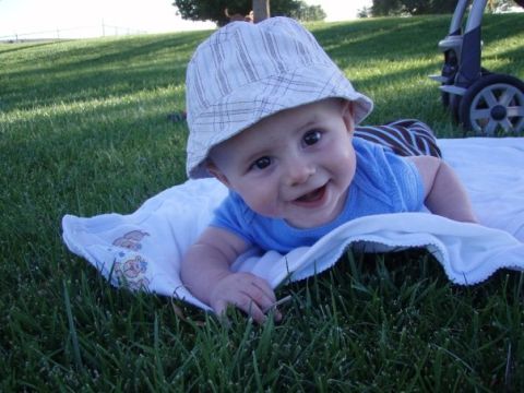 1997 Ford F-250 - Baby on a blanket on the grass, wearing a hat and blue shirt.