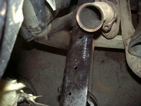 1979 Ford Bronco - Close-up of exhaust pipe and frame component with stamped part number.