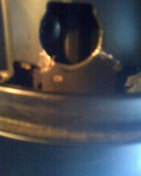 1989 Ford Bronco - A blurry close-up shows a part of a steering column, with visible metallic and plastic textures.