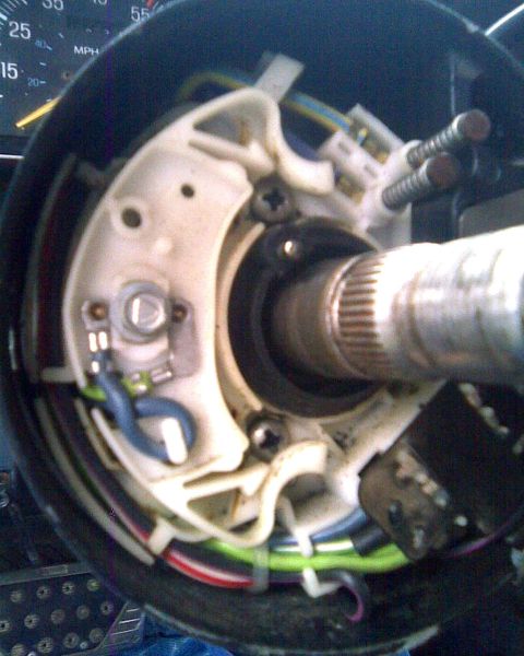 1989 Ford Bronco - Steering wheel removed to expose the top of the column: the white plastic turn-signal/multifunction switch housing, the splined steering sh…