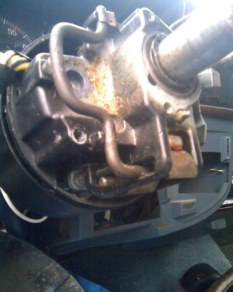 1989 Ford Bronco - Close-up of a disassembled steering column with the plastic shrouds removed, exposing the cast-aluminum housing, the tilt mechanism and the…
