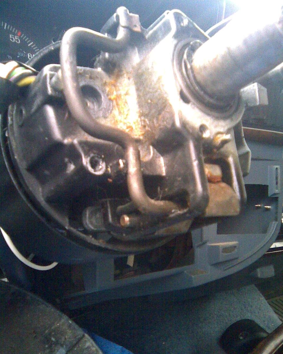 Steering column with shrouds removed showing tilt housing, shift tubes and dash cluster