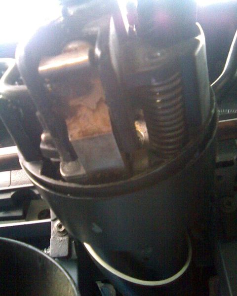 1989 Ford Bronco - Looking down into the top of a disassembled steering column with the upper shroud removed, exposing the internal shift-tube linkage, a coil…