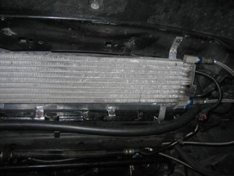 1996 Ford Thunderbird - Aftermarket transmission cooler with braided lines, mounted beneath the vehicle.