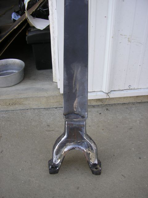 1996 Ford Bronco - A driveshaft yoke with two bolt holes is shown resting on a concrete surface.