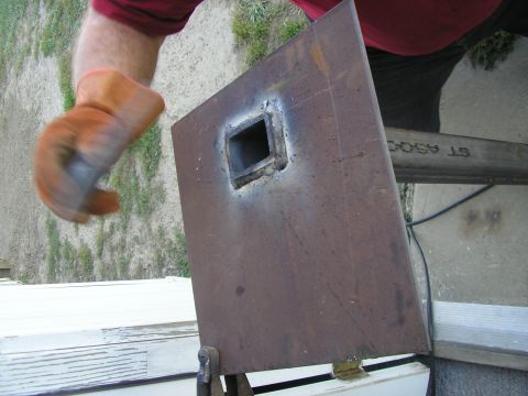 1996 Ford Bronco - A metal plate with a square hole is being worked on, with a person's gloved hand visible.
