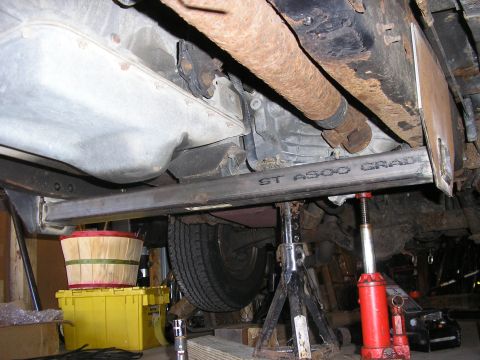1996 Ford Bronco - The underside of a vehicle is shown with mechanical components and support equipment.