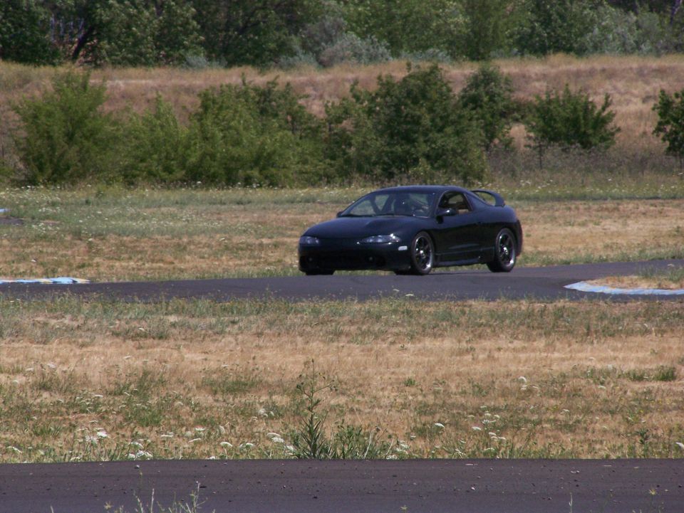 Black Mitsubishi Eclipse GSX on a race track, front 3/4 view