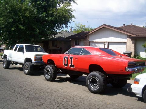 1991 Ford Crown Victoria - A lifted 1969 Dodge Charger, famously known as the "General Lee", is parked on a residential street.