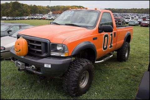 1991 Ford Crown Victoria - This orange pickup truck is decorated with the number '01' and a jack-o'-lantern on its front grille.