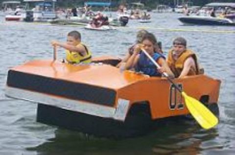 1991 Ford Crown Victoria - Children paddle an orange boat designed to look like a car on a busy lake with other boats in the background.
