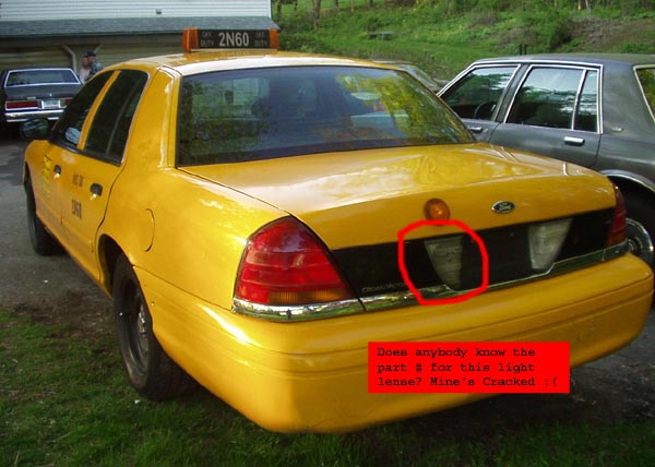 Rear of yellow Crown Victoria taxi with red circle marking cracked license plate light lens